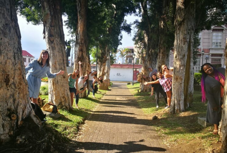 A group of students posing next to trees.
